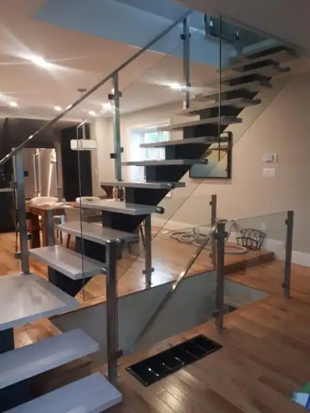 Mono stringer staircase with wood treads, a black steel support and glass railings.