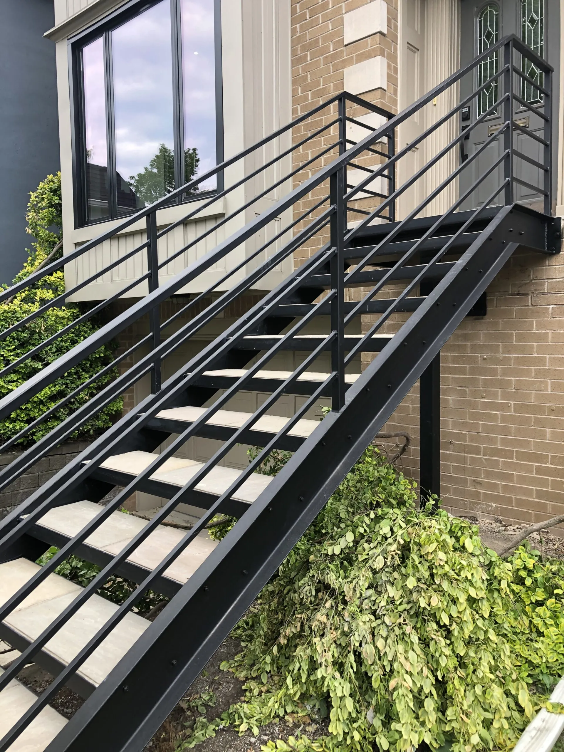 Modern staircase with laser-cut double steel stringers and open tread design in a contemporary interior or exterior space.