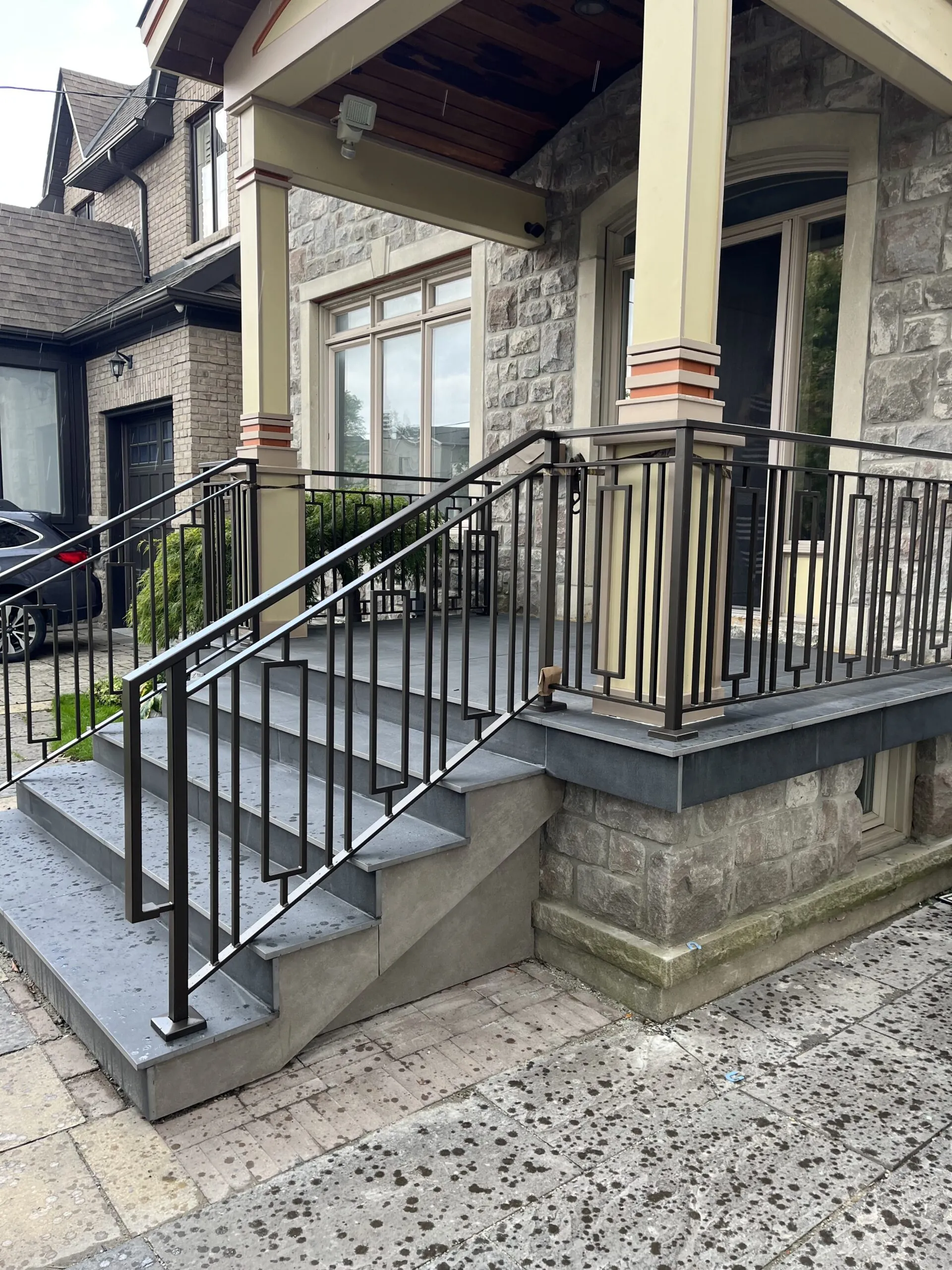 Modern outdoor railing system featuring custom geometric vertical metal pickets installed on a balcony or terrace.