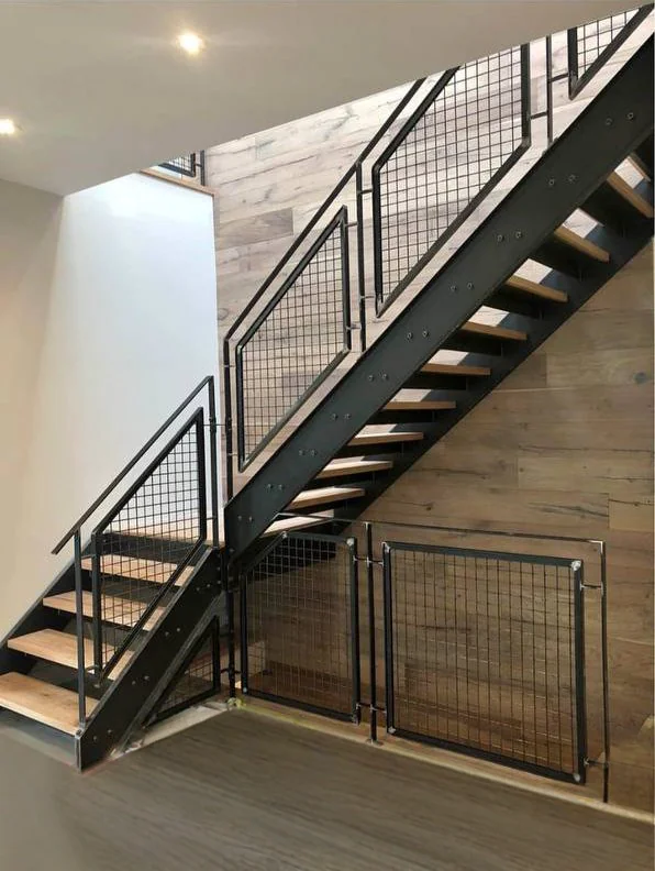 Indoor double-stringer metal stairs with metal railings.