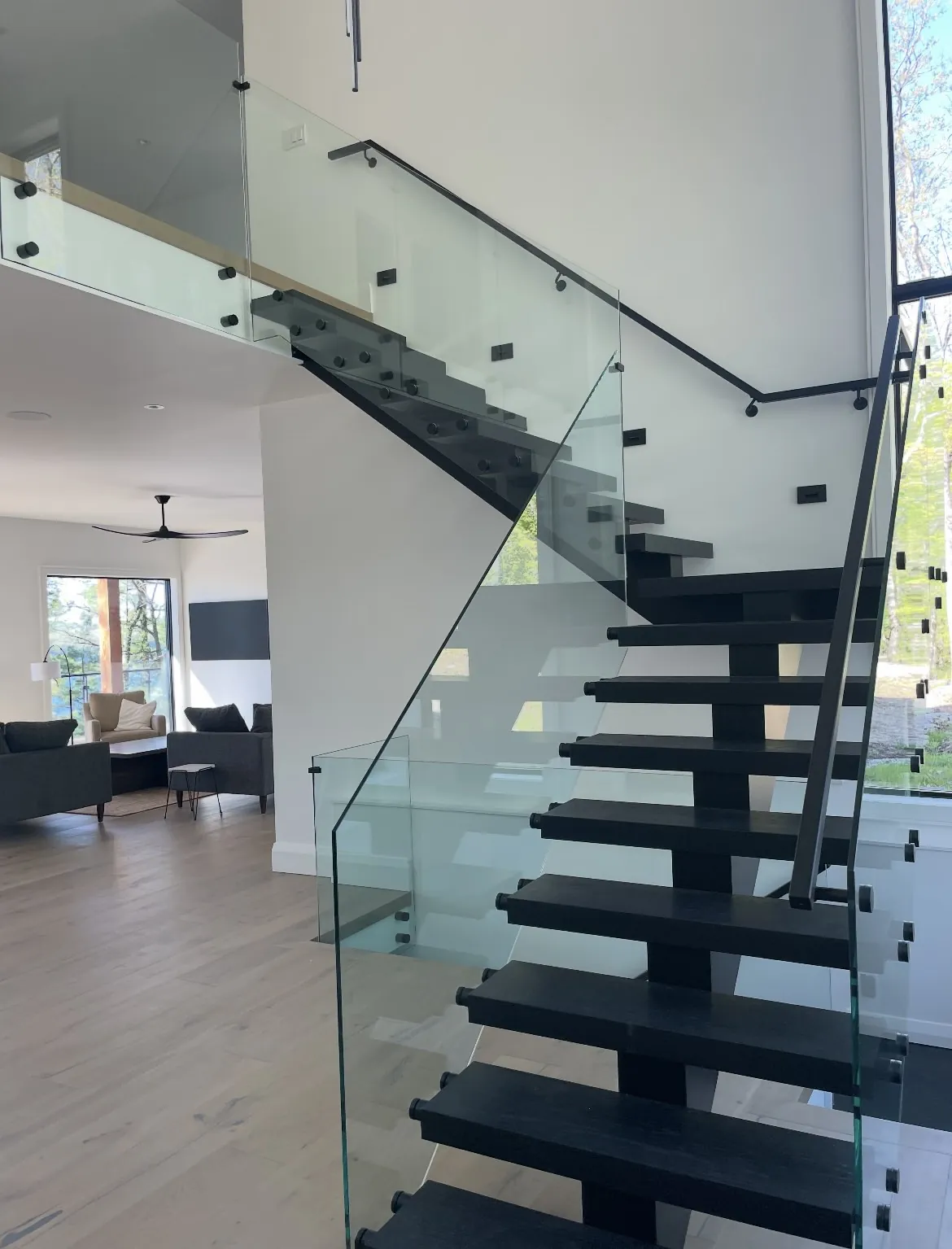 Modern mono-stringer staircase with glass railing by Modern Stairs Plus